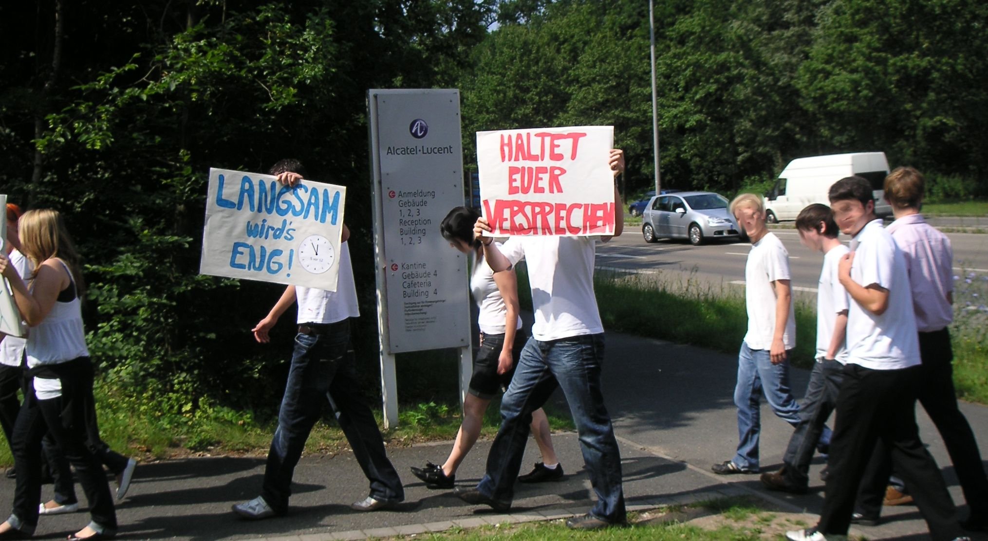 Jugend am Firmenschild mit Plakaten